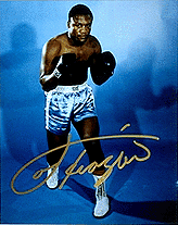 color photo of Joe Frazier in a boxing stance, autographed in gold by Frazier